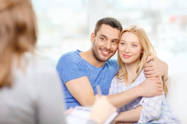 Pareja feliz recibiendo consejería profesional